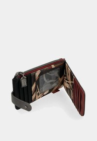 Portafoglio pieghevole con motivo astratto, finestra ID trasparente, slot per carte multiple, tasca per monete con zip e cinturino con chiusura a scatto su sfondo bianco.