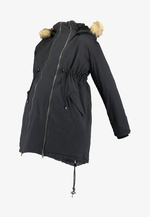 Parka negra con capucha y ribete de piel sintética, cierre frontal de cremallera, cintura ajustable con cordón y dos bolsillos laterales. Tela resistente al agua, diseño de longitud media.