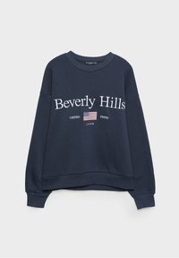 Sweat-shirt bleu marine avec le texte « Beverly Hills », un petit drapeau des États-Unis et « UNITED STATES 1999 » imprimé en dessous du texte.