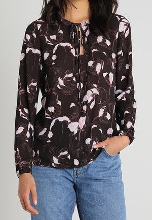 Zwarte bloemenblouse met roze accenten, lange mouwen, strikdetail bij de hals, lichte stof en een losse pasvorm, gecombineerd met denim jeans.