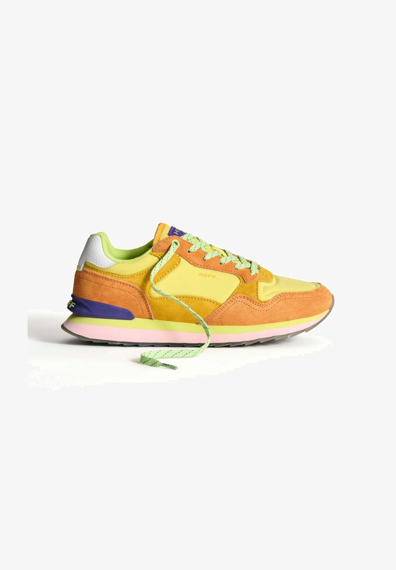 Bunt gefärbte Sneaker mit Wildleder- und Mesh-Materialien in Orange, Gelb und Grün. Merkmale sind runde Schnürsenkel, ein lila Akzent an der Ferse und eine rosa Sohle.