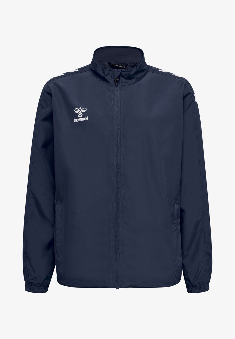 Marinblå lättviktsjacka med fullständig dragkedja fram, stående krage och elastiska ärmslut. Har vit logotyp och axelaccenter.