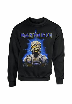 Black sweatshirt featuring "Iron Maiden" logo in yellow. Central graphic depicts a mummy-like character with chains against a blue electric background.