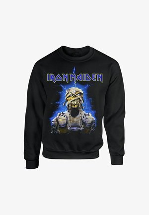 Felpa nera con il logo "Iron Maiden" in giallo. Grafica centrale che rappresenta un personaggio simile a una mummia con catene su uno sfondo blu elettrico.