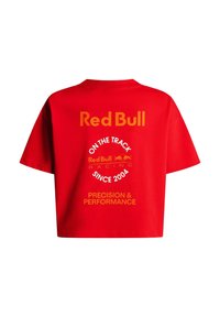 Rood cropped T-shirt met de teksten "Red Bull," "On the Track," "Since 2004," en "Precision & Performance" op de achterkant gedrukt.