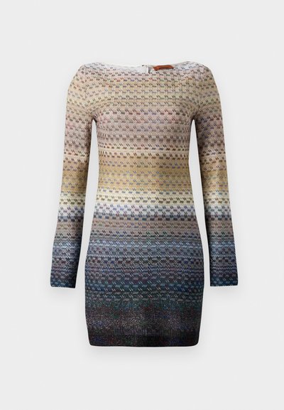 Ilga rankovė su tekstūruotu megztiniu, kuris pasižymi spalvų gradientu nuo grietinėlės iki tamsiai mėlynos, su geometriniais raštais visame paviršiuje.