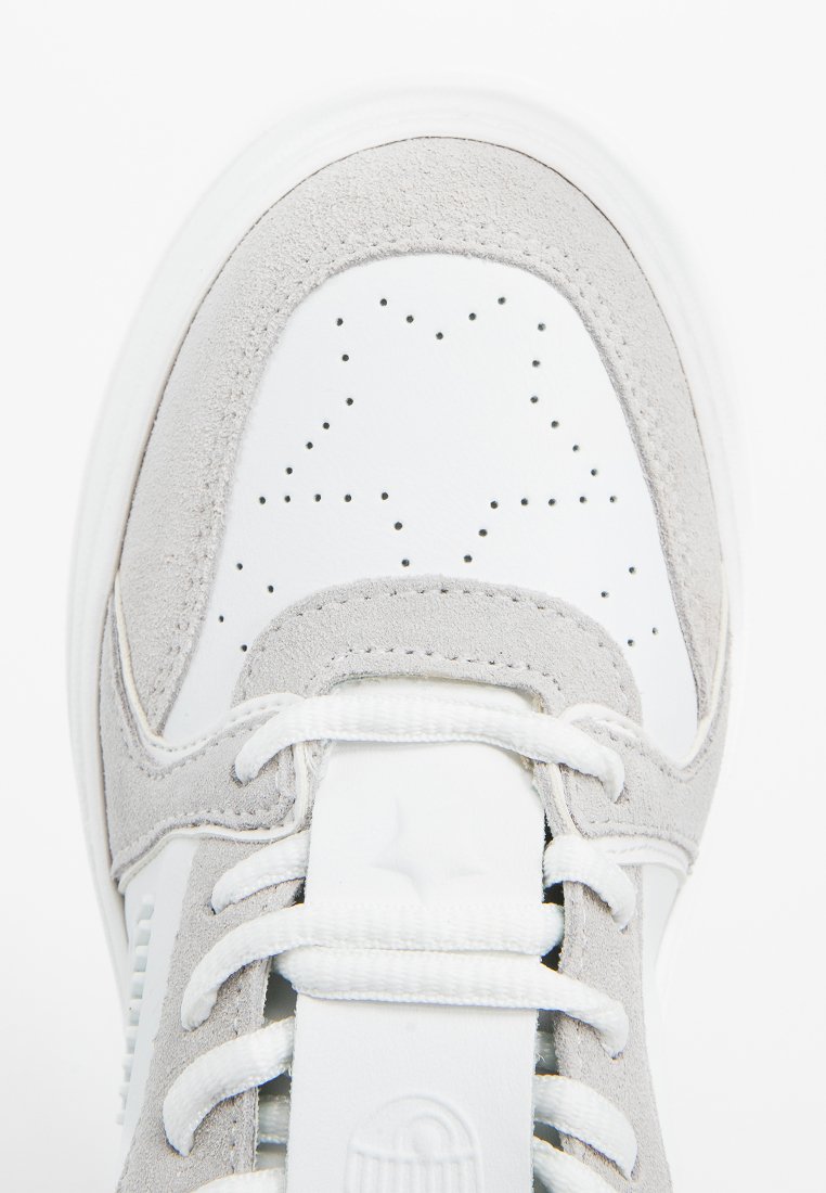 Zapatilla con parte superior de cuero blanco y detalles en ante gris, con perforaciones y cordones blancos. Punta redonda con suela de goma duradera.