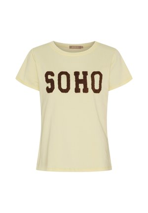 Lysegul t-shirt med korte ærmer og rund halsudskæring, dekoreret med store brune teksturerede bogstaver, der staver "SOHO" hen over brystet.