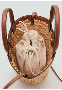 Woven straw handbag with brown leather accents, featuring a light tan fabric drawstring pouch inside. Rounded shape, smooth texture.