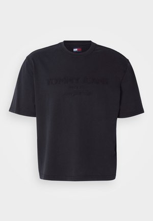 Čierne tričko s krátkym rukávom vyrobené z bavlny, na prednej strane s vyrazeným logom „TOMMY JEANS“ a textom „SINCE 1985“. Klasický dizajn s okrúhlym výstrihom.