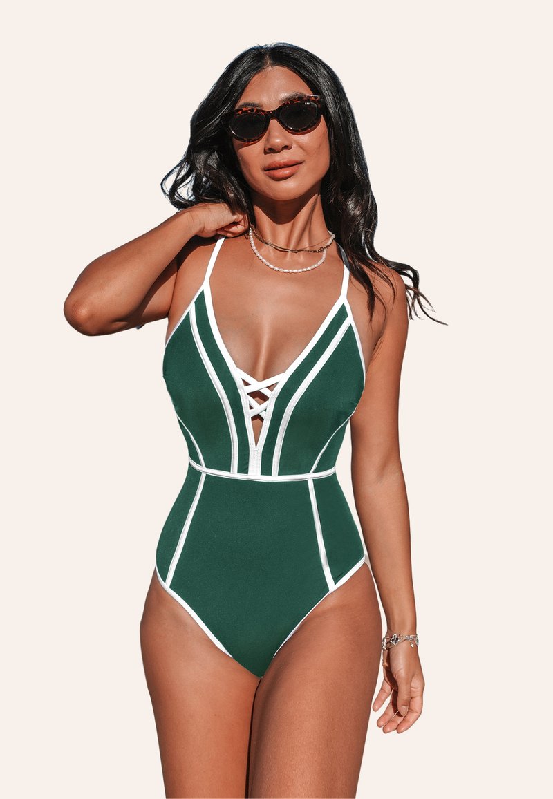 Costume da bagno intero verde con linee accentate bianche, scollatura a V profonda, fronte incrociato e spalline sottili. Texture liscia, design aderente.