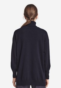 Marineblå turtlenecktröja av mjukt tyg, med avslappnad passform, ribbade ärmslut och nederkant, samt sänkt axelsömmar.