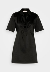 Musta lyhythihainen mekko, joka on valmistettu sileästä kankaasta. Mekossa on kaulus ja rypistyksellä varustettu keskikohta, jossa on pyöreä aukko. Yksinkertainen, suora siluetti.