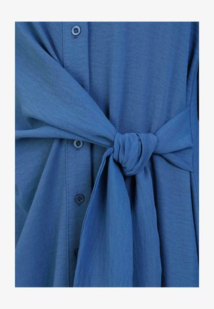 Blaue Bluse mit Krawattenbund, aus leichtem, strukturiertem Stoff mit glatter Oberfläche.