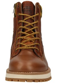 Brown leather boot with yellow laces, textured sides, padded collar, and a sturdy rubber sole. Features a logo label on the tongue.