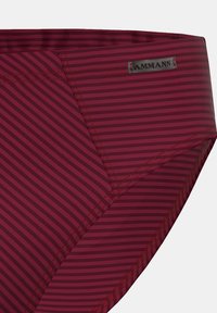 Burgunderfärgade badbyxor i kort modell med horisontella ränder, mjukt tyg och kontrasterande sömmar. Inkluderar en liten logotags nära midjan.