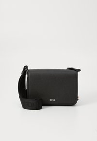 Black crossbody bag made of textured material, featuring a logo on the front, adjustable strap, and rectangular shape.
