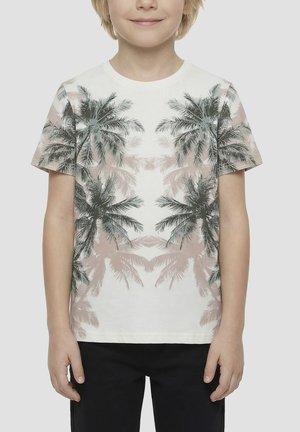 Child wearing white short-sleeve t-shirt with mirrored palm tree print and black pants, standing against a plain background.