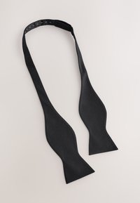Black bow tie made of textured fabric, featuring a classic shape with split ends and an adjustable collar strap.