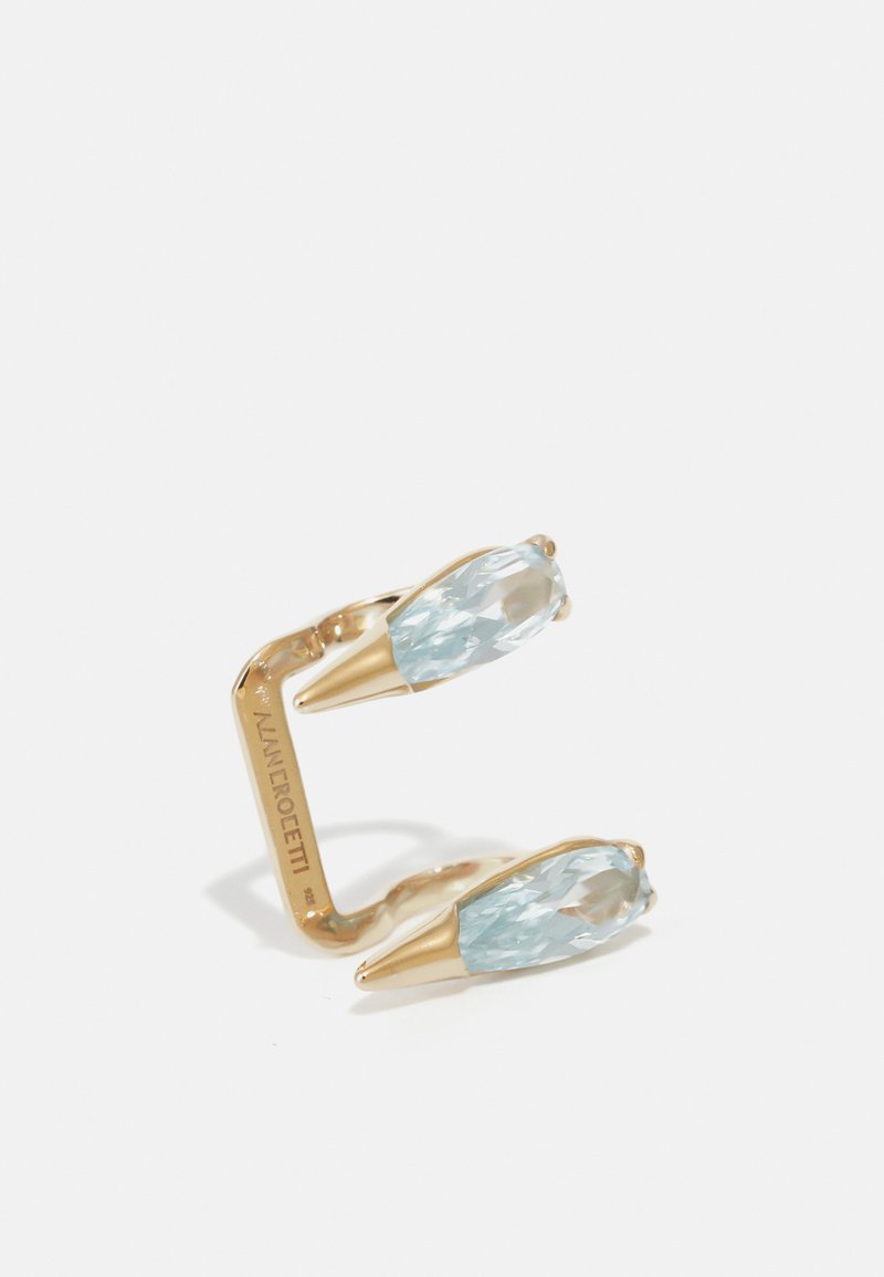 Gold-tone ear cuff featuring two light blue, faceted gemstones with a tapered design, attached to a smooth, curved base.