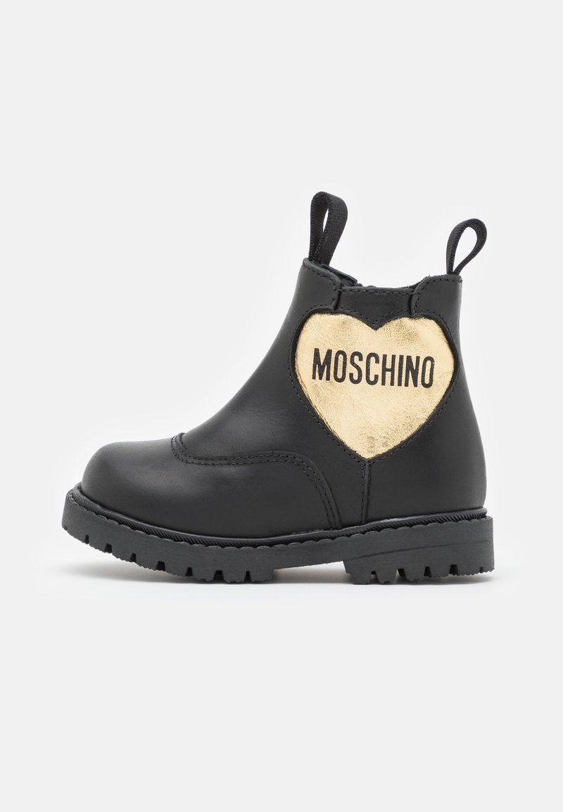 Bottechette en cuir noir avec un accent en forme de cœur doré portant l'inscription "MOSCHINO". Semelle texturée et languettes pour un enfilage facile.