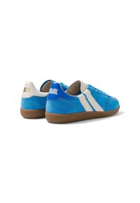 Paire de baskets en daim bleu avec bandes latérales blanches, semelles en caoutchouc marron et écussons de talon brandés, vues de l'arrière.