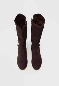 Smeđe antilop čizme do koljena s naboranim dizajnom, koje imaju zlatni patentni zatvarač na vanjskoj strani i glatku unutarnju podstavu.