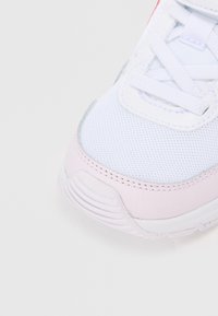 Biely teniska s vrchnou časťou z oka a jemnými ružovými koženými akcentmi. Má šnúrky, vystuženú špičku a textúrovanú gumovú podrážku.