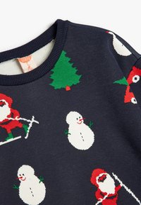 Suéter azul marino con motivos navideños: Papá Noel rojo, muñecos de nieve, árboles verdes y un zorro, tejido en suave algodón con un cuello acanalado.
