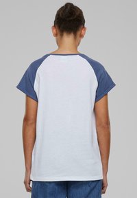 Kortærmet t-shirt med hvid krop og blå raglanærmer. Fremstillet af bomuldsstof, rund halsudsmykning og en afslappet pasform. Ingen synlige mønstre eller detaljer.