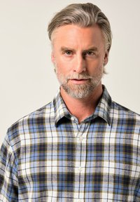 Camicia a quadri nei toni blu, bianco e oliva. Design con bottoni e colletto a ribalta. Tessuto testurizzato, che mostra un classico motivo a quadri.