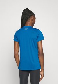 Modré sportovní tričko s krátkými rukávy, s kulatým výstřihem a jemným logem na zádech. Hladká, elastická tkanina.