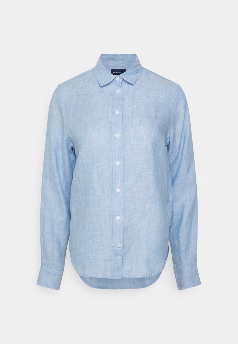 Chemise en lin bleu clair à manches longues avec fermeture boutonnée sur le devant et col classique, présentée sur un fond blanc.