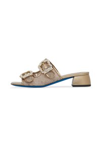 Gold lace slide sandals with two embellished buckles, open toe, and a low block heel featuring a blue sole. Detailed, textured fabric.