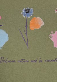 Tecido verde-azeitona apresenta estampas florais em azul e laranja, com caules roxos. O texto diz "Reclame a natureza e esteja conectado" em roxo.