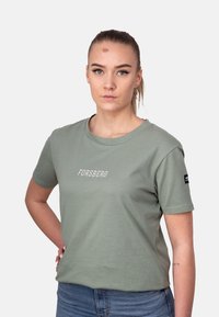 Camiseta de manga corta color verde oliva con "FORSBERG" impreso en blanco. Presenta un corte relajado y cuello redondo con un pequeño logo en la manga.