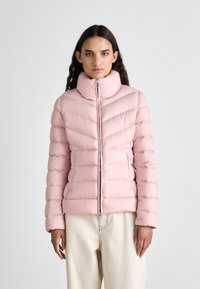 Ανοιχτό ροζ φούτερ με οριζόντια ραφή, ψηλό γιακά, μπροστινό φερμουάρ με κυκλικό κορδόνι και στενή σιλουέτα.