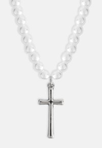 Sudraba krusta pieknei uz kakla ķēdes, ko ieskauj gludas, baltas pērlītes. Dizains ir vienkāršs ar pulētu apdari.