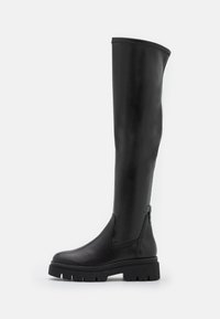 Botas negras hasta la rodilla hechas de cuero suave. Presenta una puntera redonda, suela de goma gruesa y panel lateral elástico para facilitar su uso.