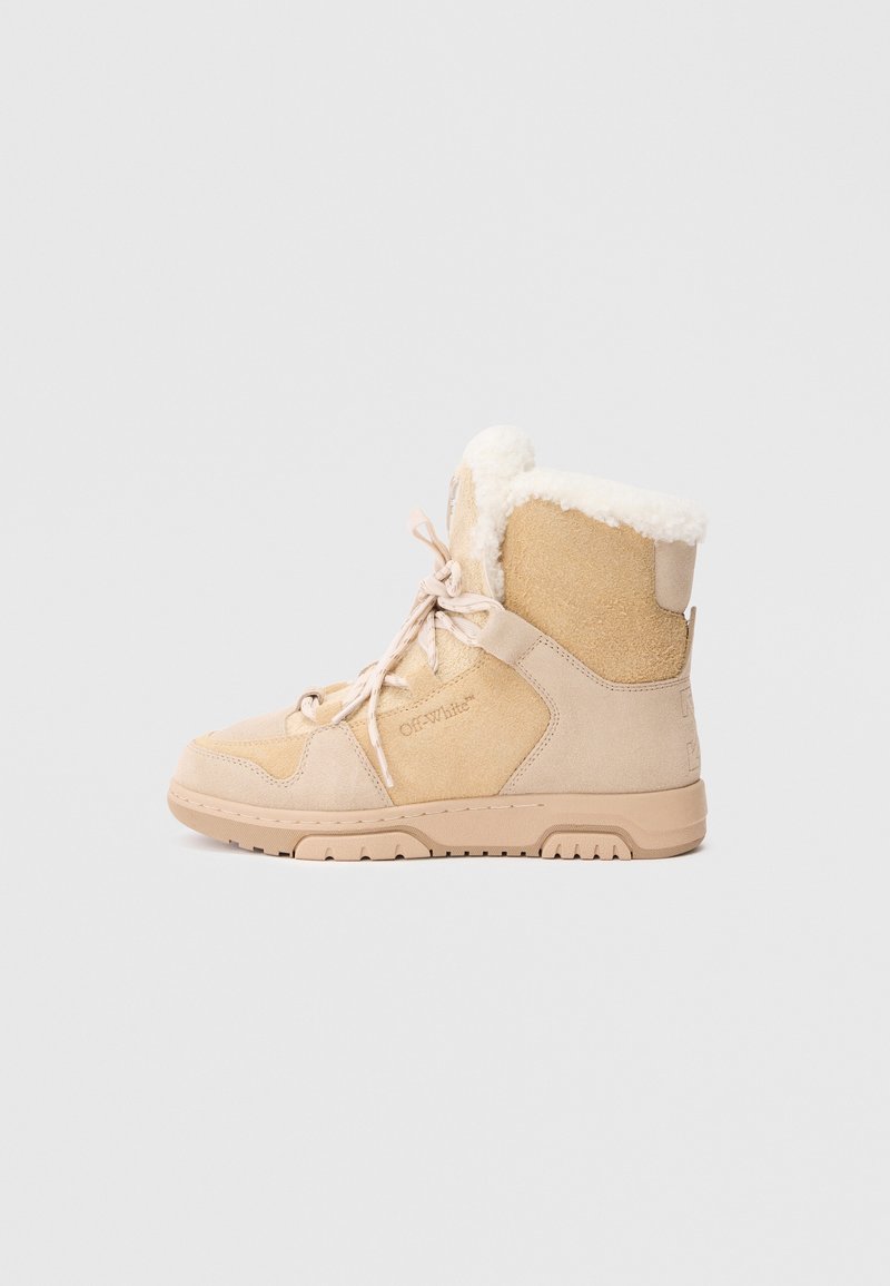 Tan suede batai su minkštiniais pūkuotais viduje, plokščiu gumuotu padu ir priekiniais raišteliais. Savybė - Off-White logotipas šone ir paminkštinta apykaklė.