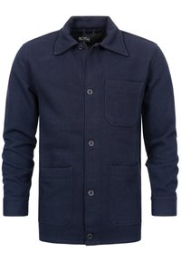 Mørkeblå herringbone jakke lavet af struktureret stof, med spidse flips, frontknapper og to store frontlommer.