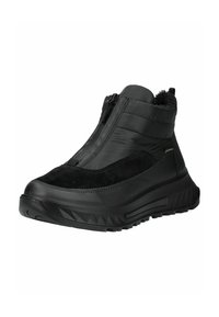 Schwarze Knöchelboots aus einer Kombination von glattem Leder und Wildleder, mit einem Reißverschluss und einer strukturierten Gummisohle mit Wellenmuster für besseren Halt.
