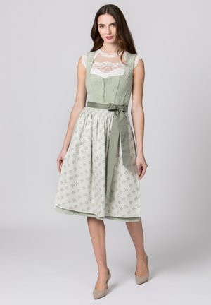 Green patterned dirndl dress featuring a fitted bodice with lace detail, a smocked waist, and a flowing skirt cinched with a matching ribbon.
