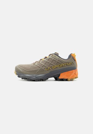 Bruine en oranje trailrunningschoen met een zool met textuur voor grip en het logo "LA SPORTIVA" aan de zijkant, gezien vanaf de buitenkant.