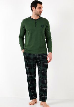 Grünes Langarmoberteil mit einem schwarzen Akzentkragen, Knopfdetails und einem karierten Muster auf der passenden grünen und schwarzen Hose.