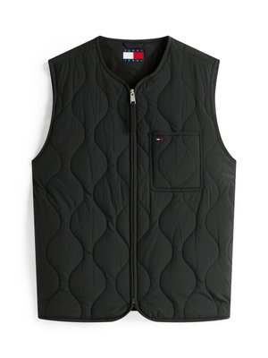 Gilet nero trapuntato con colletto alto, chiusura frontale con zip e tasca sul petto con un piccolo logo. Tessuto liscio con un motivo a onde.