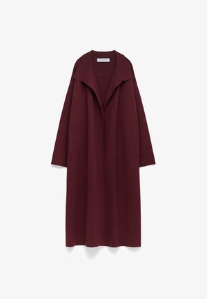 Long manteau bordeaux à ouverture frontale, avec un large col et des poches latérales, présenté à plat sur un fond blanc.