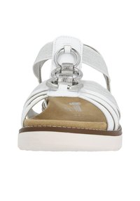 Witte sandaal met meerdere banden, voorzien van metalen ronde accenten en een gevoerde beige binnenzool. Gladde textuur, platte zool.