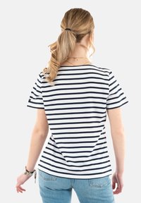 Camiseta de rayas con rayas horizontales en azul marino sobre un fondo blanco, de mangas cortas y un corte relajado, combinada con jeans azul claro.