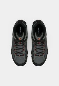 Gray hiking shoes with mesh and synthetic material, featuring red accents, black laces, and a textured rubber sole. Merrell branding visible.